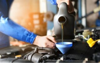 mechanic pouring engine oil into a car engine, demonstrating an engine oil change